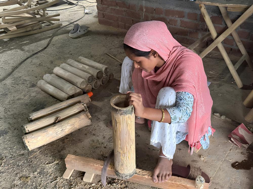 An artisan shaping bamboo by hand
